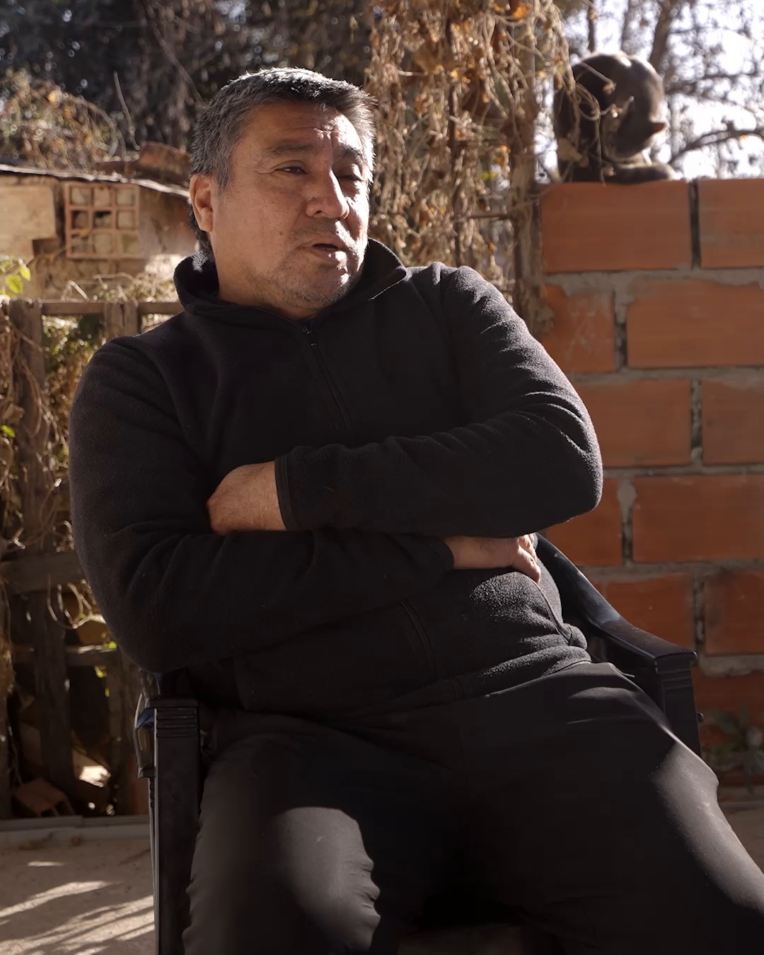 Hombre de mediana edad, Jorge López, vecino de la comunidad, sentado con los brazos cruzados.