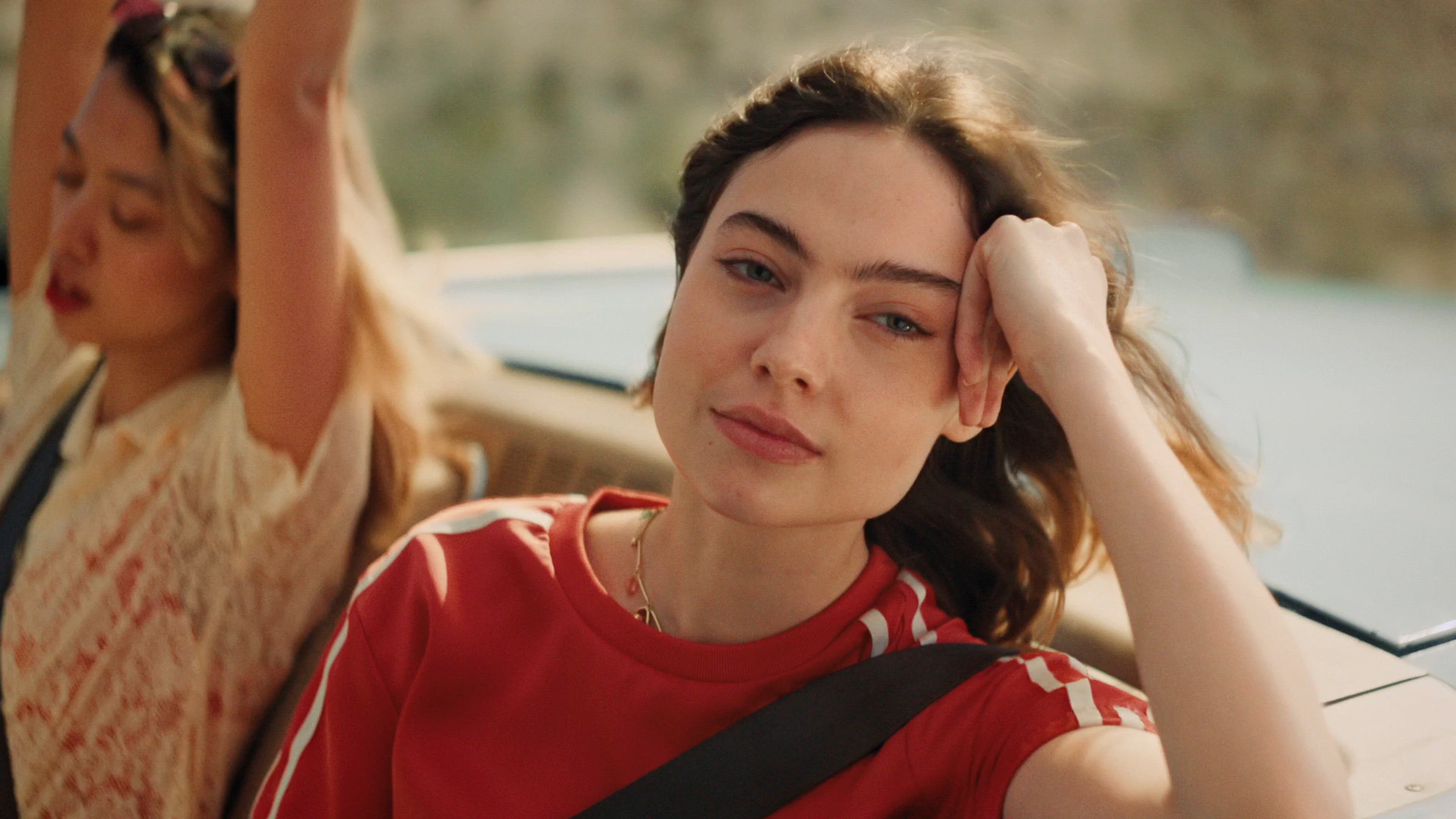 Video prikazuje osobu koja se opušteno vozi u automobilu i uživa u trenutku tokom putovanja.